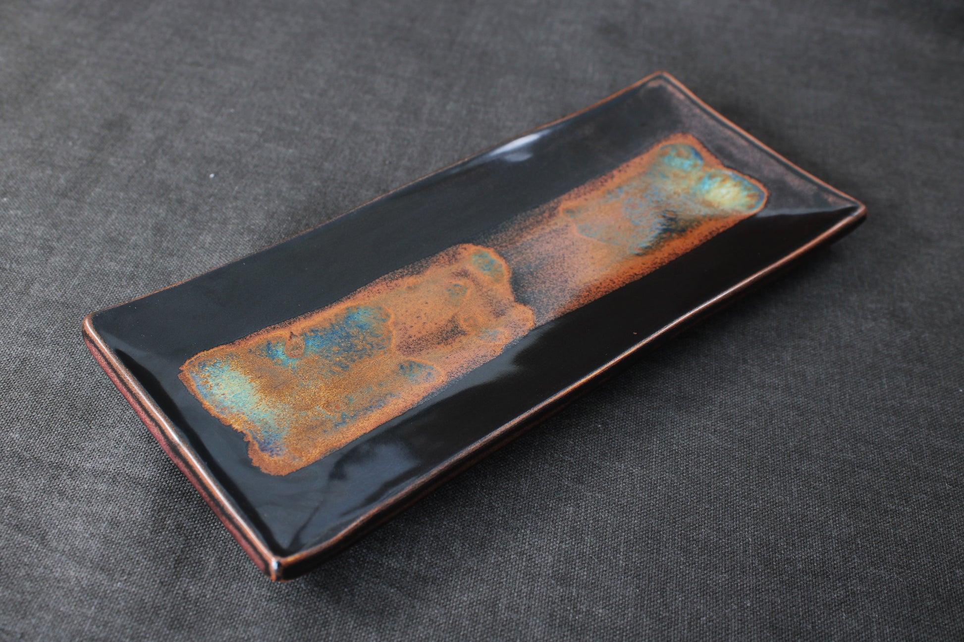 handmade sushi plate with tenmoku glaze top view