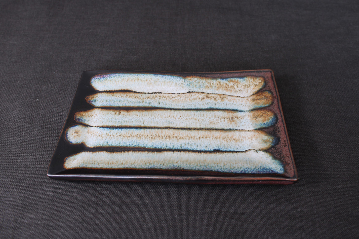 sushi plate with tenmoku glaze top view